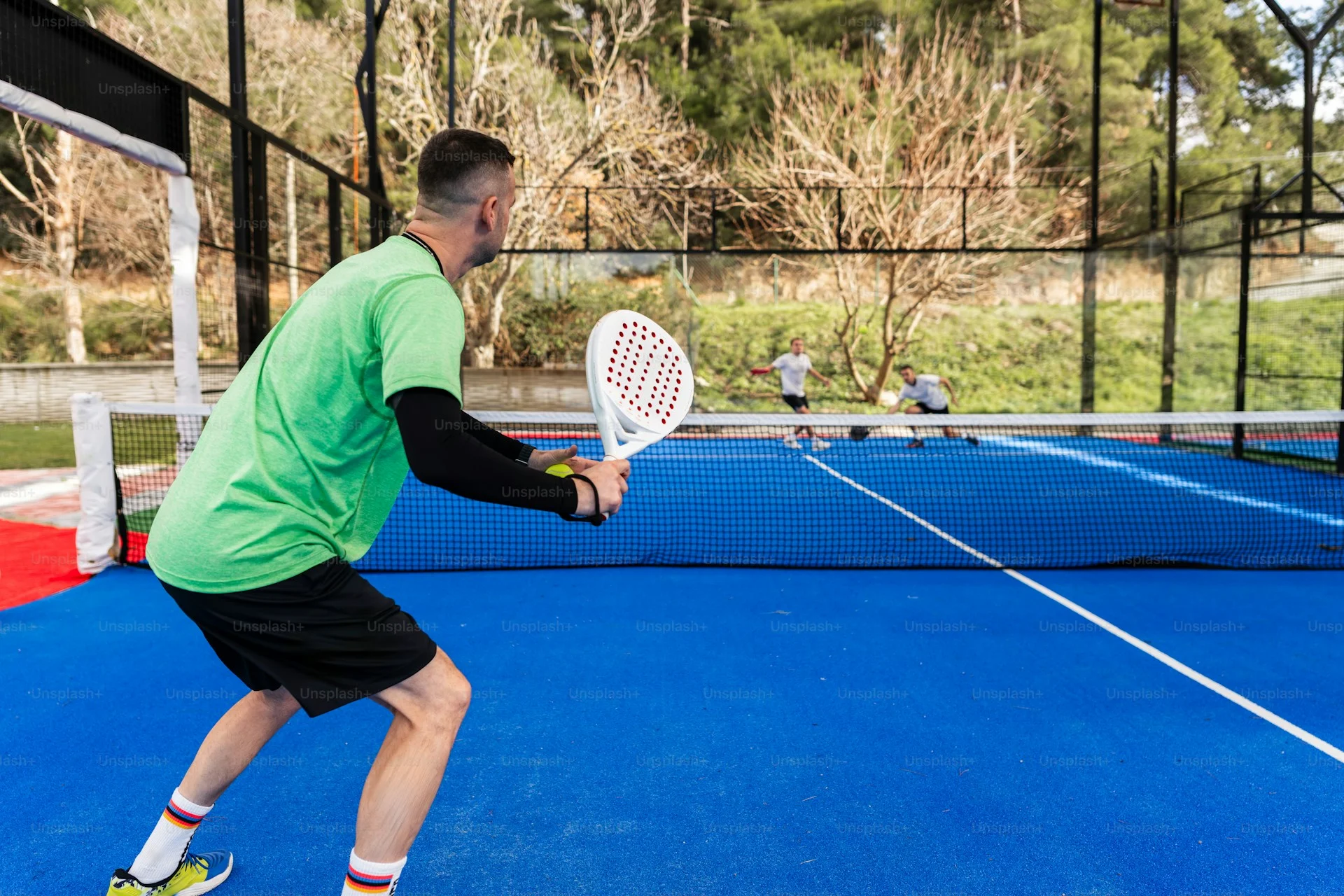 Beginner padel players discussing strategy on court